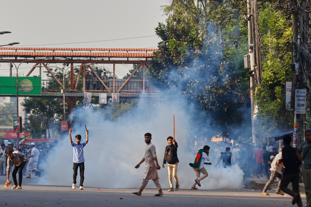 Protesters throw stones and shout slogans during a standoff with police outside the demolished residence of Sheikh Mujibur Rahman, Bangladesh's former leader and the father of the country's ousted Prime Minister Sheikh Hasina after the verdict against Hasina, in Dhaka, Bangladesh, Monday, Nov. 17, 2025. (AP Photo/ Rajib Dhar)