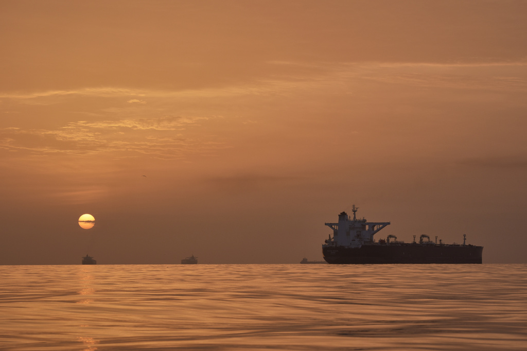 The sun rises behind tankers anchored in the Strait of Hormuz off the coast of Qeshm Island, Iran, Saturday, April 18, 2026. (AP Photo/Asghar Besharati)