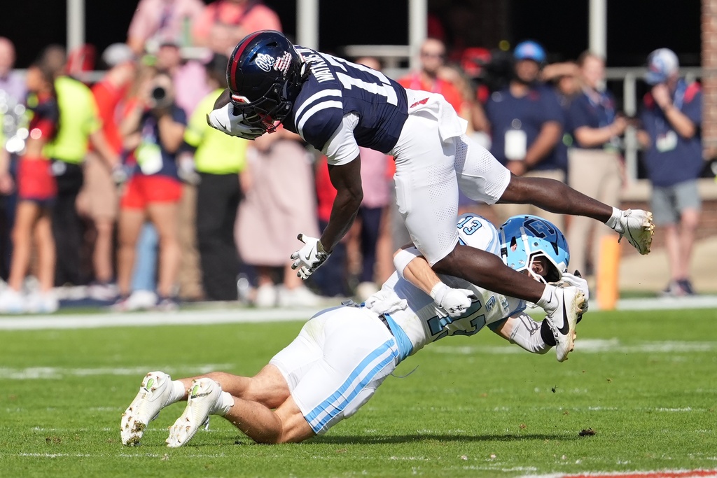 Mississippi wide receiver Winston Watkins (17) is upended after catching a pass by The Citadel defensive back Cale Williams (13) during the first half of an NCAA college football game, Saturday, Nov. 8, 2025, in Oxford, Miss. (AP Photo/Rogelio V. Solis)