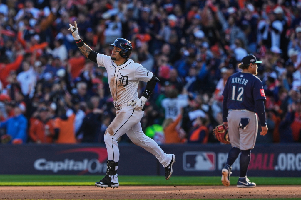 Detroit Tigers' Javier Báez celebrates after hitting a two-run home run while running past Seattle Mariners first baseman Josh Naylor (12) during the sixth inning in Game 4 of baseball's American League Division Series Wednesday, Oct. 8, 2025, in Detroit. (AP Photo/Ryan Sun)