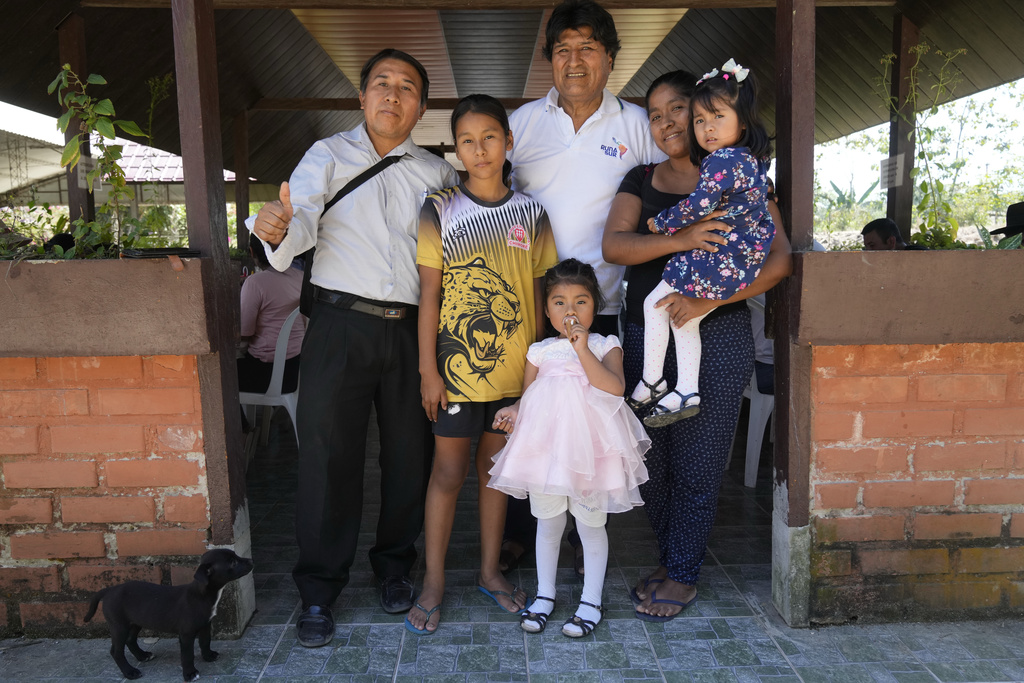 Former President Evo Morales, who is promoting a null vote campaign on Sunday's presidential and legislative elections, poses for a picture with a family in Lauca N, Chapare region, Bolivia, Saturday, Aug. 16, 2025. (AP Photo/Jorge Saenz)