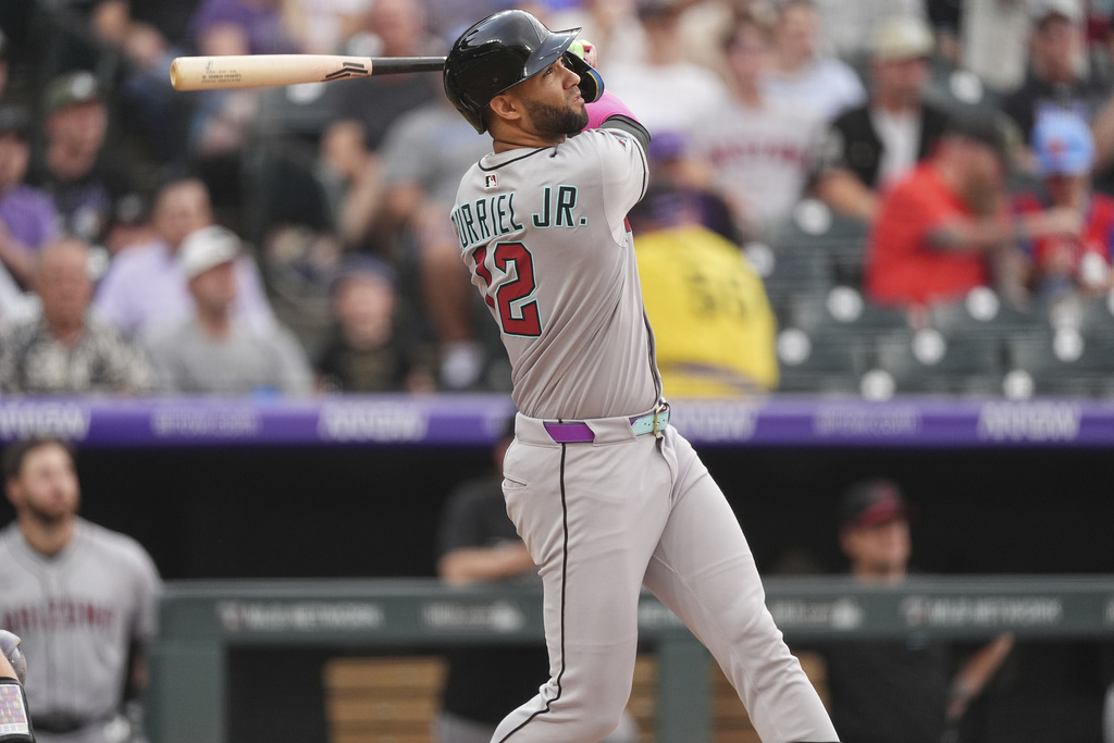 Arizona Diamondbacks' Lourdes Gurriel Jr. follows the flight of his three-run home run off Colorado Rockies starting pitcher Bradley Blalock in the first inning of a baseball game Thursday, Aug. 14, 2025, in Denver. (AP Photo/David Zalubowski)