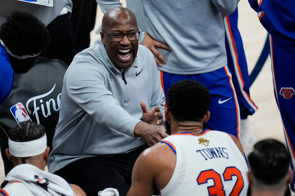 New York Knicks head coach Mike Brown laughs with center Karl-Anthony Towns (32) during a time out during the second half of Game 1 of the NBA Finals basketball series against the San Antonio Spurs, Wednesday, June 3, 2026, in San Antonio. (AP Photo/David J. Phillip)