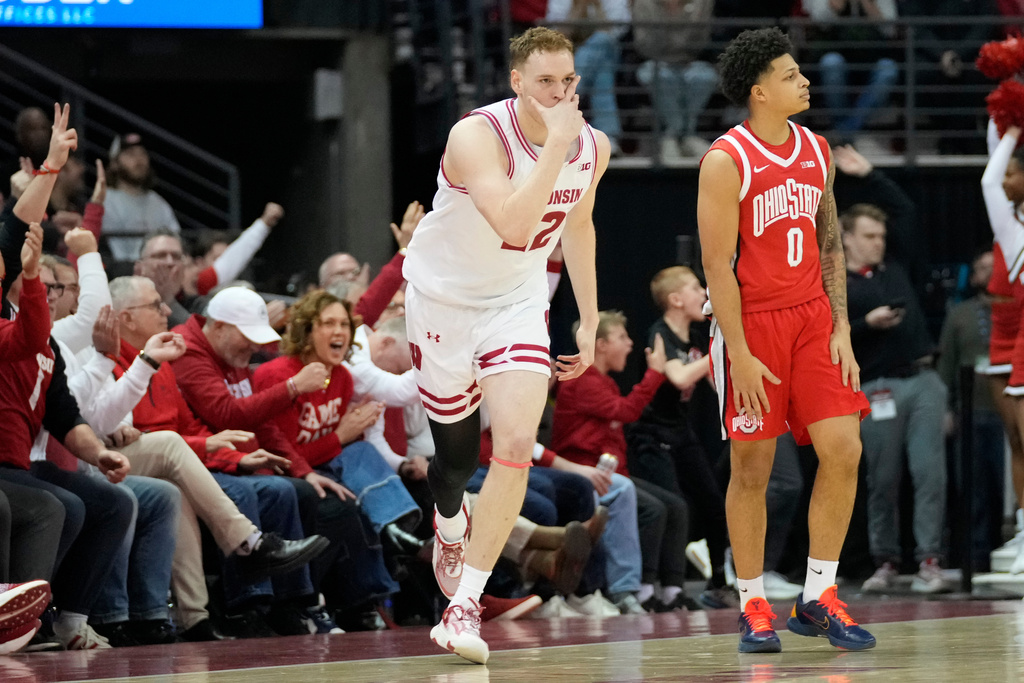 Wisconsin forward Austin Rapp, left, reacts to scoring a three-point basket as Ohio State guard John Mobley Jr. (0) looks on during the first half of an NCAA college basketball game Saturday, Jan. 31, 2026, in Madison, Wis. (AP Photo/Kayla Wolf)