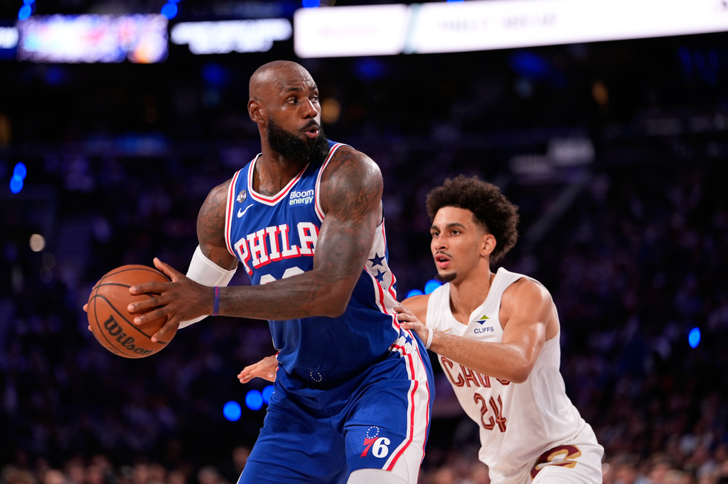 Philadelphia 76ers' LeBron James, left, tries to get past Cleveland Cavaliers' Tyrese Proctor during the first half of an NBA basketball game Thursday, Oct. 22, 2026, in Philadelphia. (AP Photo/Matt Slocum)