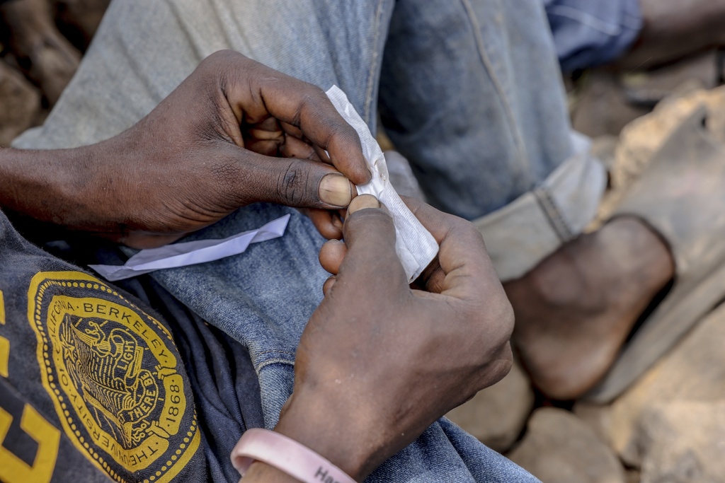FILE - A boy rolls kush at the Baghdad Den in Freetown, Sierra Leone, March 11, 2025. (AP Photo/Caitlin Kelly, File)