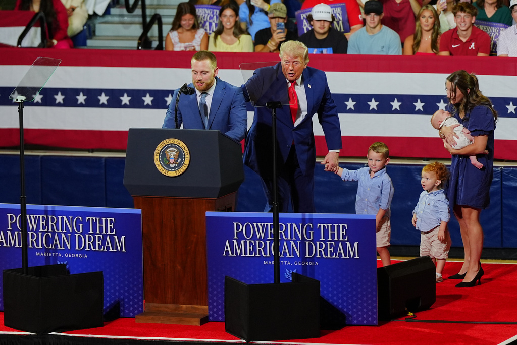 President Donald Trump, center, invites a family on stage to speak about Trump Accounts at Wheeler High School, Wednesday, July 22, 2026, in Marietta, Ga. (AP Photo/Julia Demaree Nikhinson)