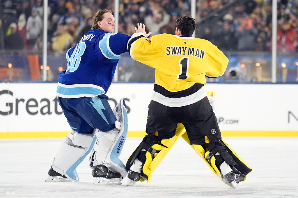 Tampa Bay Lightning goaltender Andrei Vasilevskiy (88) and Boston Bruins goaltender Jeremy Swayman (1) fight during the second period of a Stadium Series NHL hockey game Sunday, Feb. 1, 2026, in Tampa, Fla. (AP Photo/Chris O'Meara)
