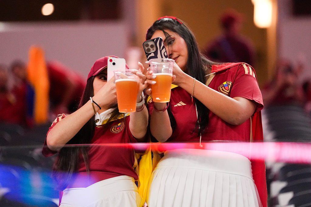 FILE - Venezuela fans take photos of their beers before a Copa America quarterfinal soccer match between Venezuela and Canada, July 5, 2024, in Arlington, Texas. (AP Photo/Julio Cortez, File)