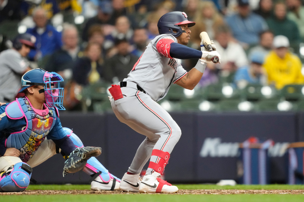 Washington Nationals' Jorbit Vivas hits a sacrifice bunt as Milwaukee Brewers catcher William Contreras, left, looks on during the ninth inning of a baseball game, Friday, April 10, 2026, in Milwaukee. (AP Photo/Kayla Wolf)