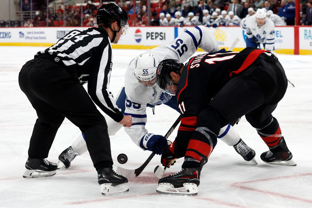 Toronto Maple Leafs' Nicolas Roy (55) faces off with Carolina Hurricanes' Jordan Staal (11) during the first period of an NHL hockey game in Raleigh, N.C., Thursday, Dec. 4, 2025. (AP Photo/Karl DeBlaker)