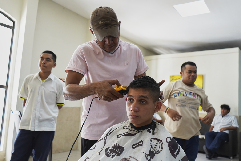 A youth gets his hair cut at a barbershop to adhere to public school rules for hair in San Salvador, El Salvador, Friday, Aug. 22, 2025. (AP Photo/Salvador Melendez)