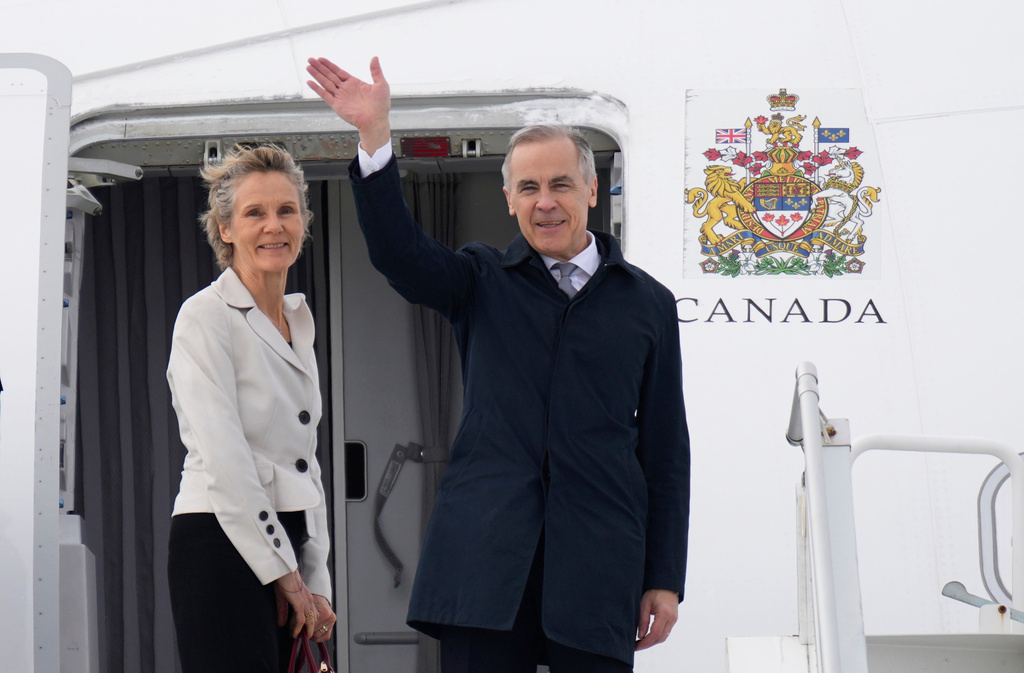 Canadian Prime Minister Mark Carney and Diana Fox Carney board a government plane in Ottawa, Thursday, Feb. 26, 2026. (Adrian Wyld/The Canadian Press via AP)