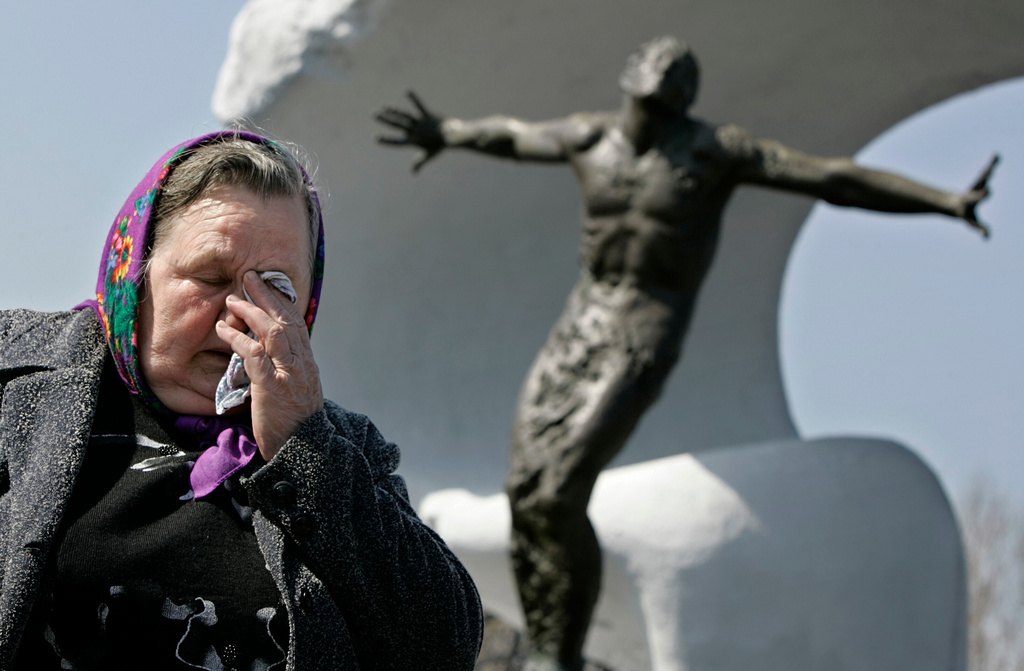 FILE – Tatyana Ignatenko, the mother of firefighter Vasily Ignatenko, grieves near his grave at Mitinskoye Cemetery in Moscow, Russia, on Wednesday, April 26, 2006, the 20th anniversary of the explosion and fire at the Chernobyl nuclear power plant in Ukraine. Vasily Ignatenko's crew was the first to respond to the disaster. (AP Photo/Alexander Zemlianichenko, File)