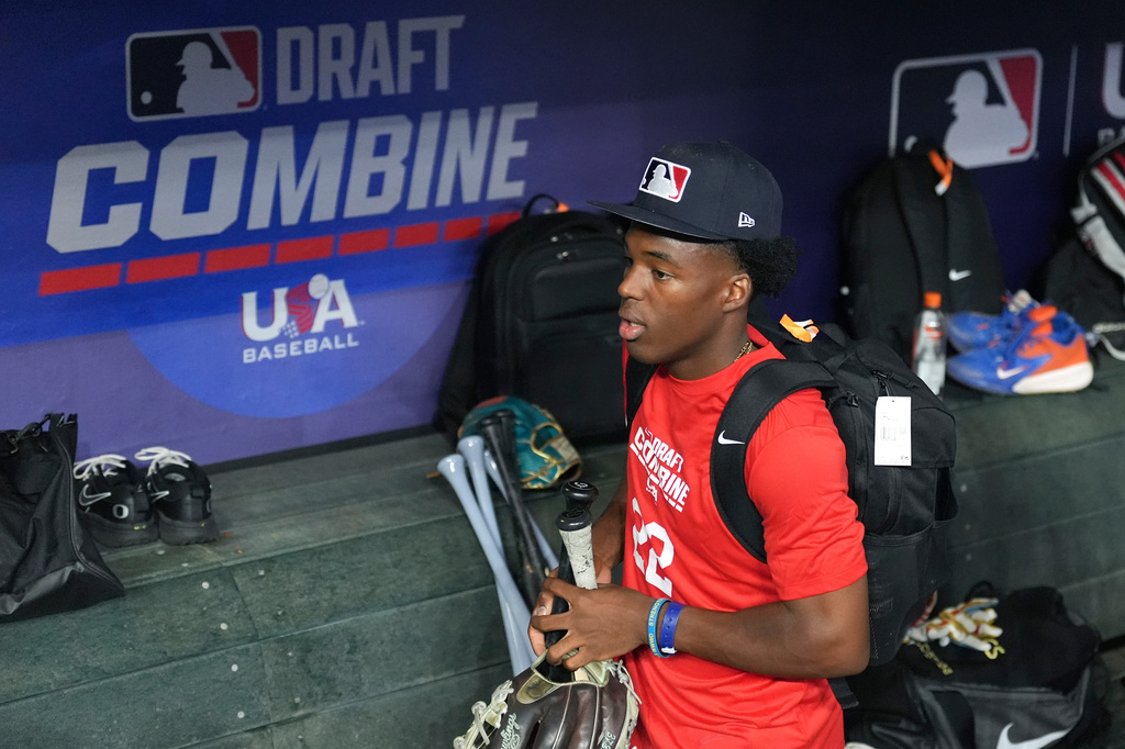 James Clark, a shortstop from St. John Bosco High School, gathers his gear in the dugout at the MLB baseball combine in Phoenix, Tuesday, June 23, 2026. (AP Photo/Ross D. Franklin)