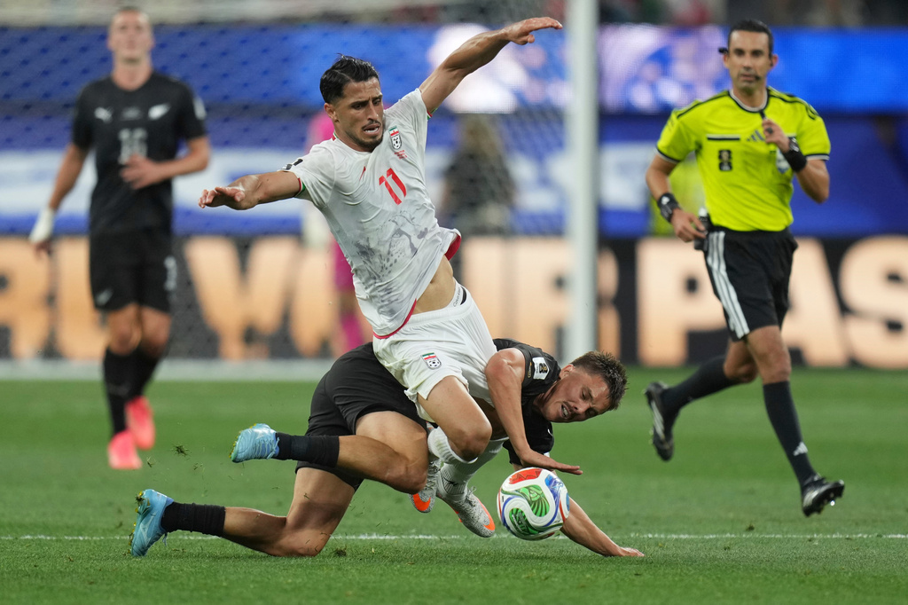 Iran's Ali Alipour (11) battles for the ball with New Zealand's Ryan Thomas (23) during the World Cup Group G soccer match between Iran and New Zealand in Inglewood, Calif., near Los Angeles, Monday, June 15, 2026. (AP Photo/Andre Penner)