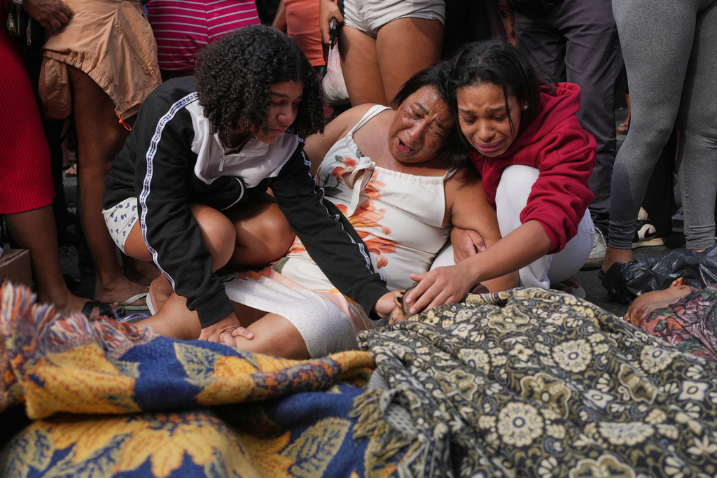 Relatives mourn over the bodies of people killed the day before during a police raid targeting the Comando Vermelho gang in the Complexo da Penha favela of Rio de Janeiro, Brazil, Wednesday, Oct. 29, 2025. (AP Photo/Silvia Izquierdo)