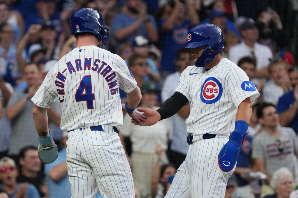 Chicago Cubs' Pete Crow-Armstrong, left, greets Seiya Suzuki, right, after they scored against the Detroit Tigers during the first inning of a baseball game Tuesday, July 21, 2026, in Chicago. (AP Photo/David Banks)