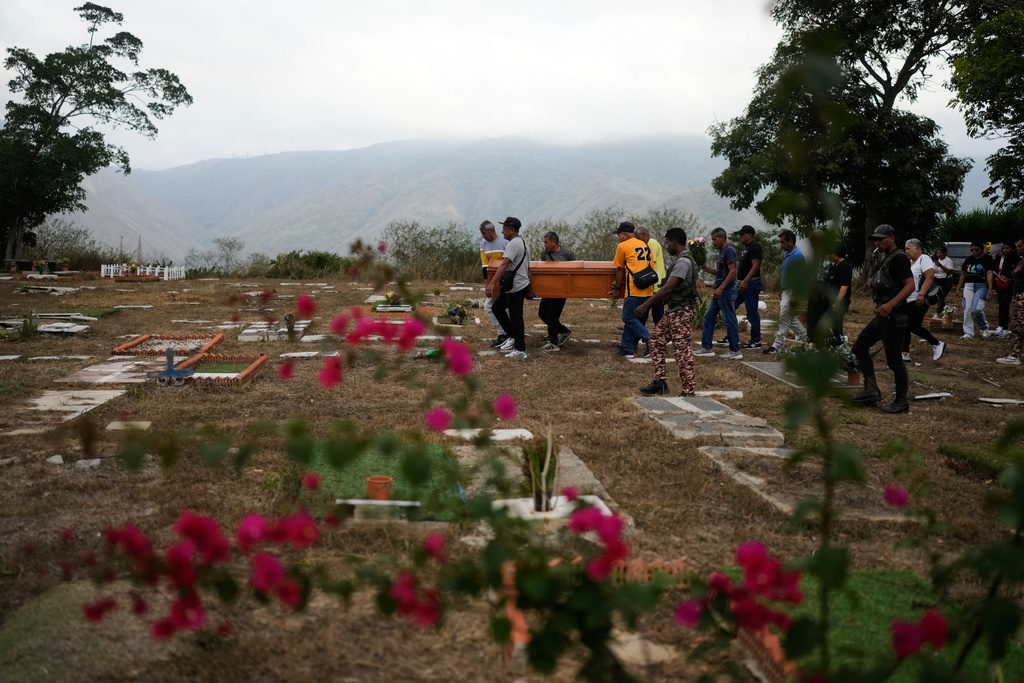 Relatives carry the coffin of Rosa Elena Gonzalez, 80, who died after her apartment was hit during a U.S. strike to capture President Nicolas Maduro, at the cemetery in La Guaira, Venezuela, Monday, Jan. 5, 2026. (AP Photo/Matias Delacroix)