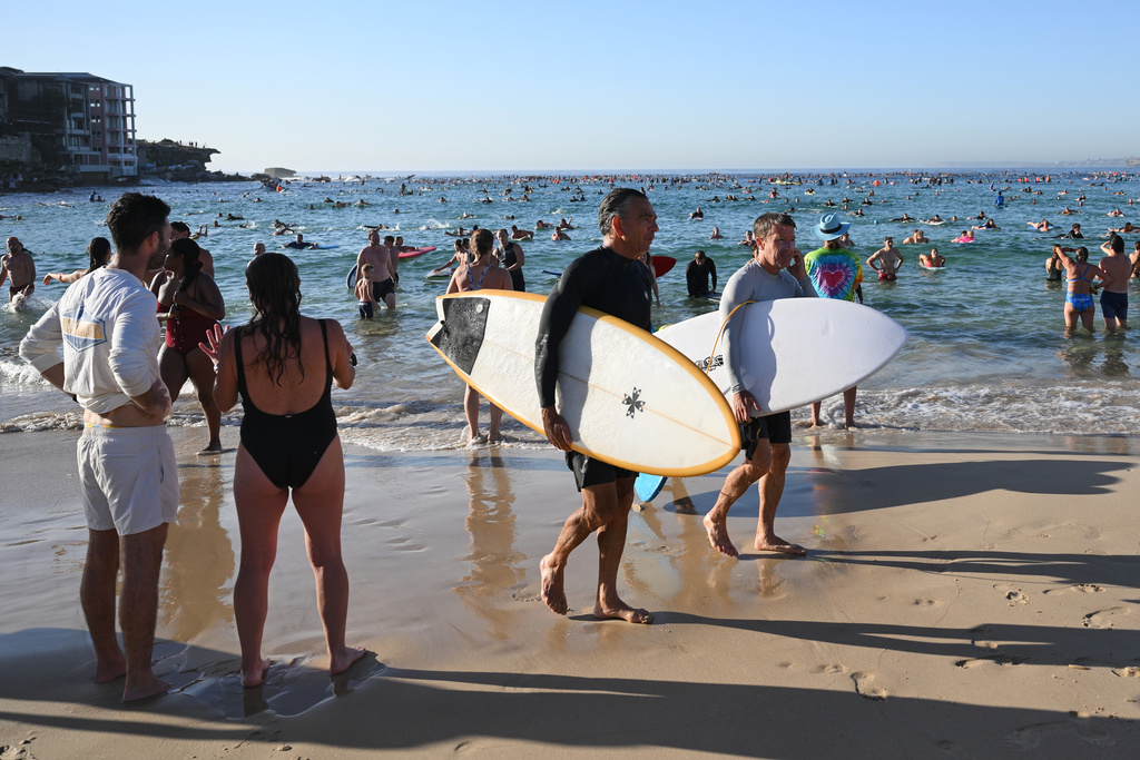 FILE - Surfers and swimmers leave the water after a tribute following last Sunday's shooting at Bondi Beach, in Sydney, Friday, Dec. 19, 2025. (AP Photo/Steve Markham,File)
