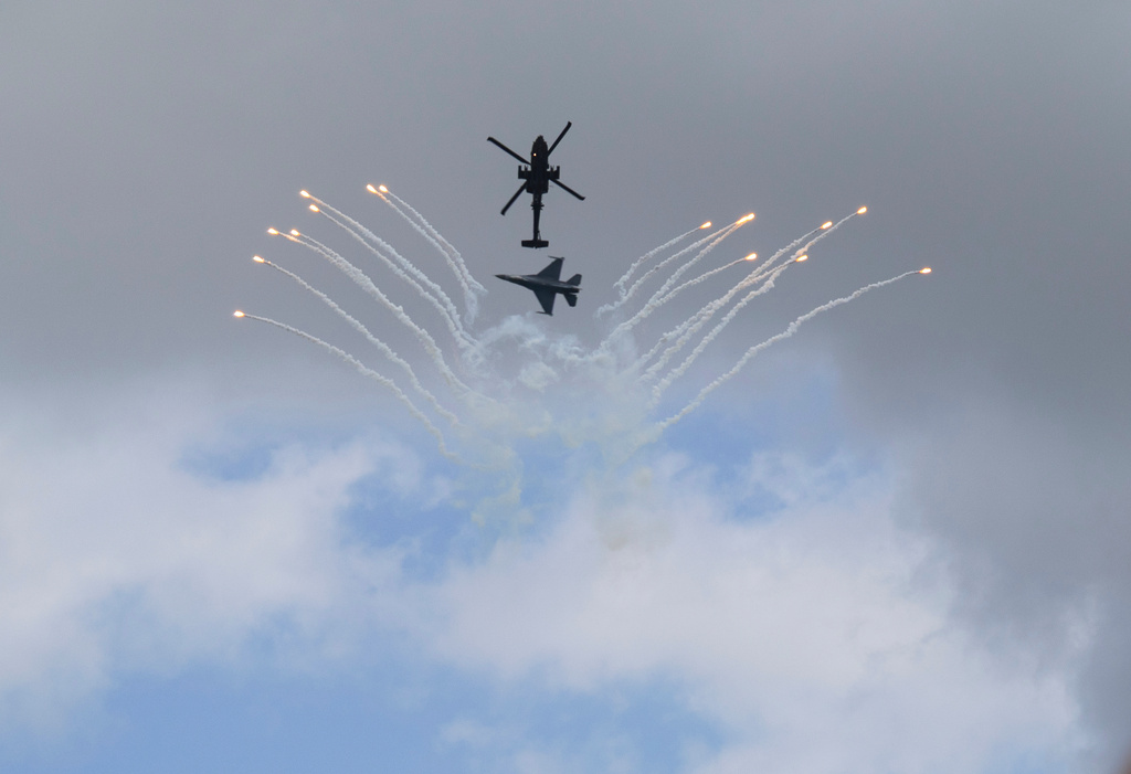 An AH-64 Apache helicopter and an F-16 fighter jet with the Singapore Armed Forces display their skills during the Singapore Air Show on Thursday, Feb. 5, 2026. (AP Photo/Anton L. Delgado)