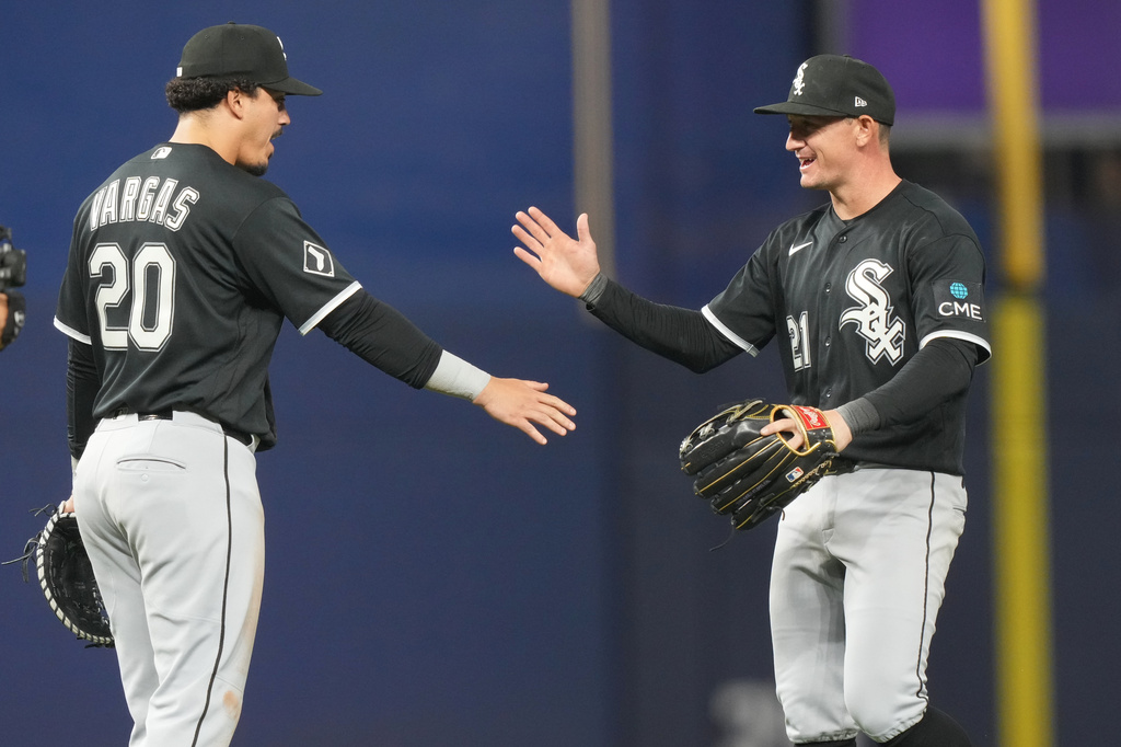 Chicago White Sox third baseman Miguel Vargas (20) and left fielder Austin Hays (21) celebrate after defeating the Miami Marlins during a baseball game Monday, March 30, 2026, in Miami. (AP Photo/Marta Lavandier)