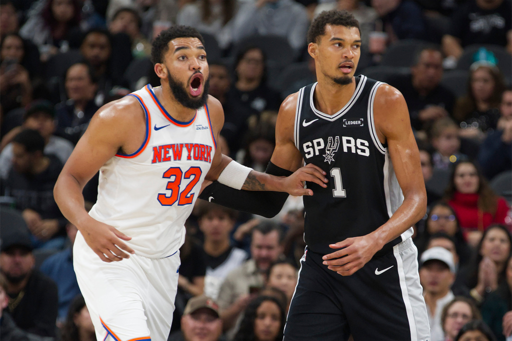 San Antonio Spurs center Victor Wembanyama (1) guards New York Knicks center Karl-Anthony Towns during the second half of an NBA basketball game, Wednesday, Dec. 31, 2025, in San Antonio. (AP Photo/Darren Abate)