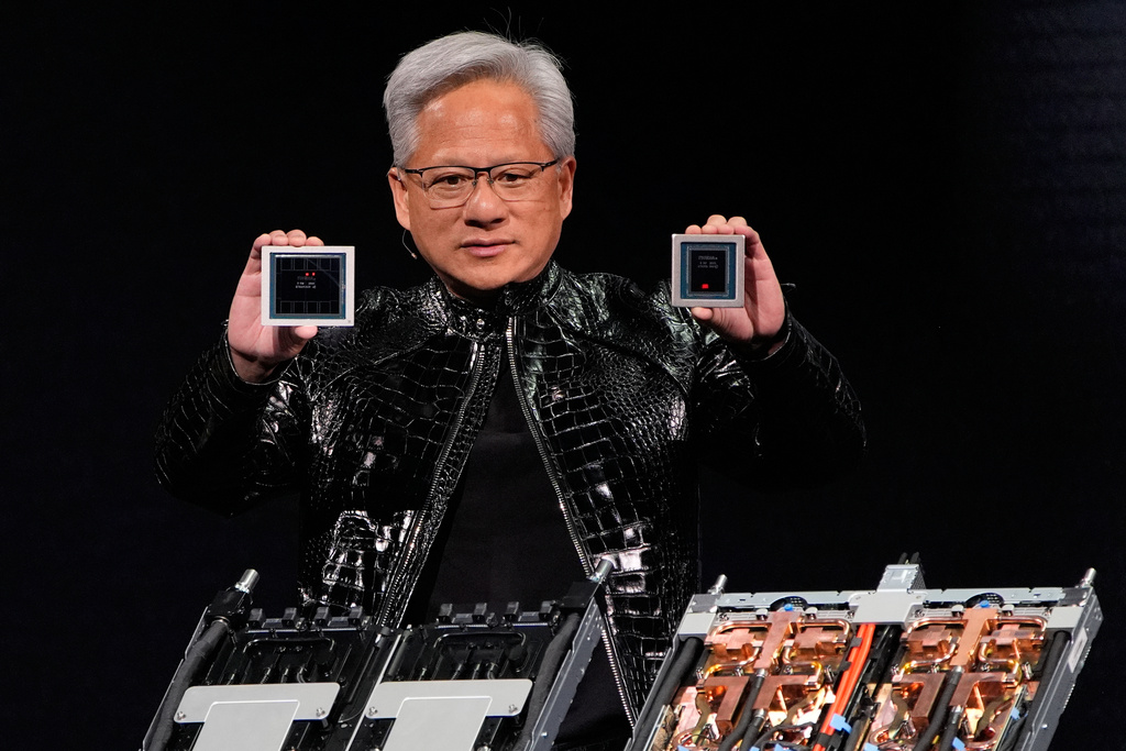 Nvidia founder and CEO Jensen Huang holds up a Rubin GPU and a Vera CPU as he speaks during a Nvidia news conference ahead of the CES tech show Monday, Jan. 5, 2026, in Las Vegas. (AP Photo/John Locher)