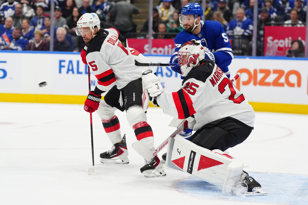New Jersey Devils goaltender Jacob Markstrom (25) watches the puck as Devils defenseman Brenden Dillon (5) and Toronto Maple Leafs center Nicolas Roy (55) battle in front during second period NHL hockey action in Toronto on Tuesday Dec. 30, 2025. (Frank Gunn/The Canadian Press via AP)