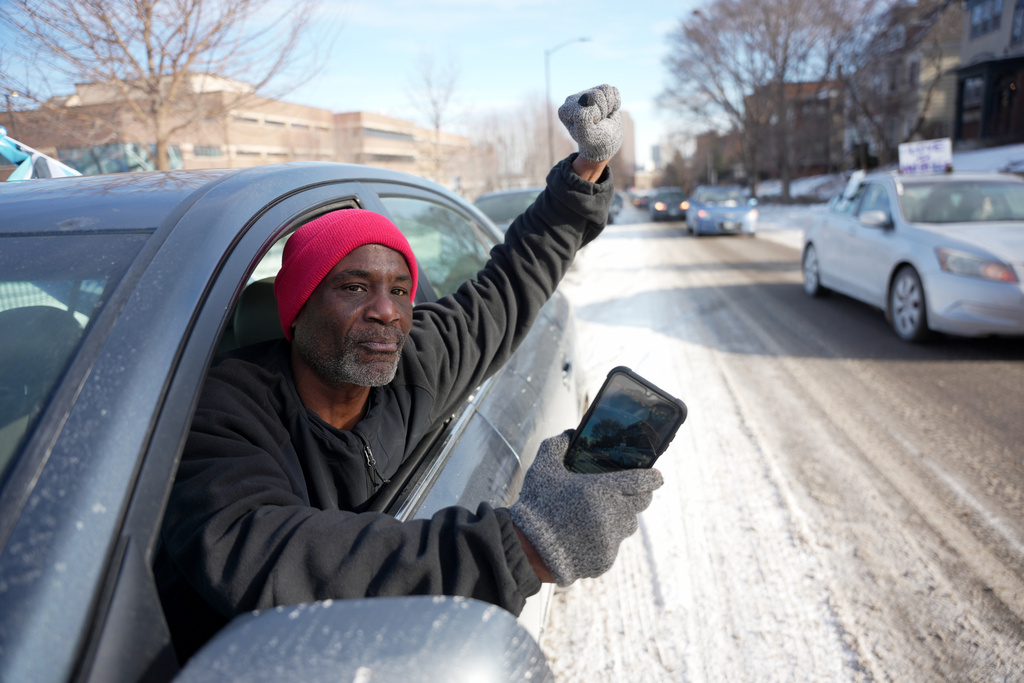 Anti-ICE protester Trahern Crews a co-founder of, Black Lives Matter, raises his fist in defiance during a caravan protest, Monday, Jan. 19, 2026 in St. Paul, Minn. (AP Photo/Angelina Katsanis)
