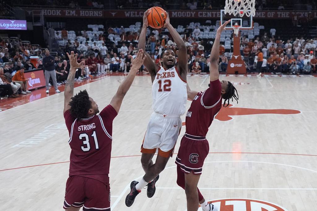 Texas guard Tramon Mark (12) drives to the basket against South Carolina forward Elijah Strong (31) and guard Kobe Knox (4) during the second half of an NCAA college basketball game in Austin, Texas, Feb. 3, 2026. (AP Photo/Eric Gay)