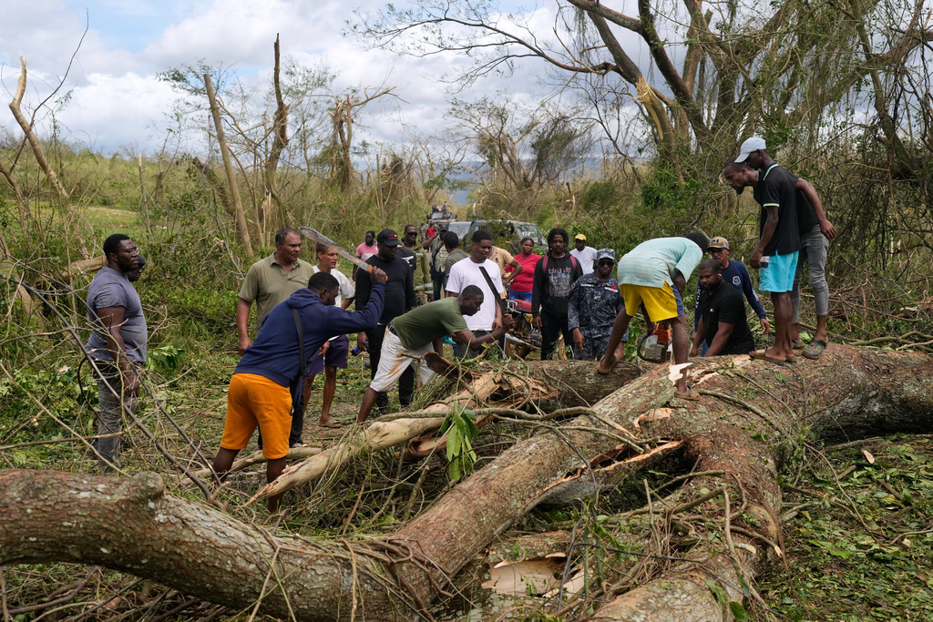 Men clear a blocked road in the aftermath of Hurricane Melissa in Santa Cruz, Jamaica, Wednesday, Oct. 29, 2025. (AP Photo/Matias Delacroix)