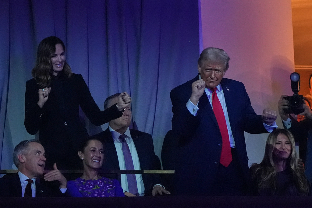 President Donald Trump dances to The Village People as Canadian Prime Minister Mark Carney, Mexican President Claudia Sheinbaum and First Lady Melania smile during the draw for the 2026 soccer World Cup at the Kennedy Center in Washington, Friday, Dec. 5, 2025. (AP Photo/Jacquelyn Martin)