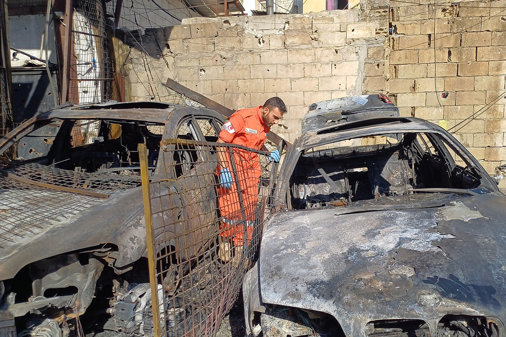A Palestinian rescue worker checks cars that were damaged in an Israeli strike on Tuesday night at the Ein el-Hilweh Palestinian refugee camp, in the southern port city of Sidon, Lebanon, Wednesday, Nov. 19, 2025. (AP Photo/Mohammed Zaatari)