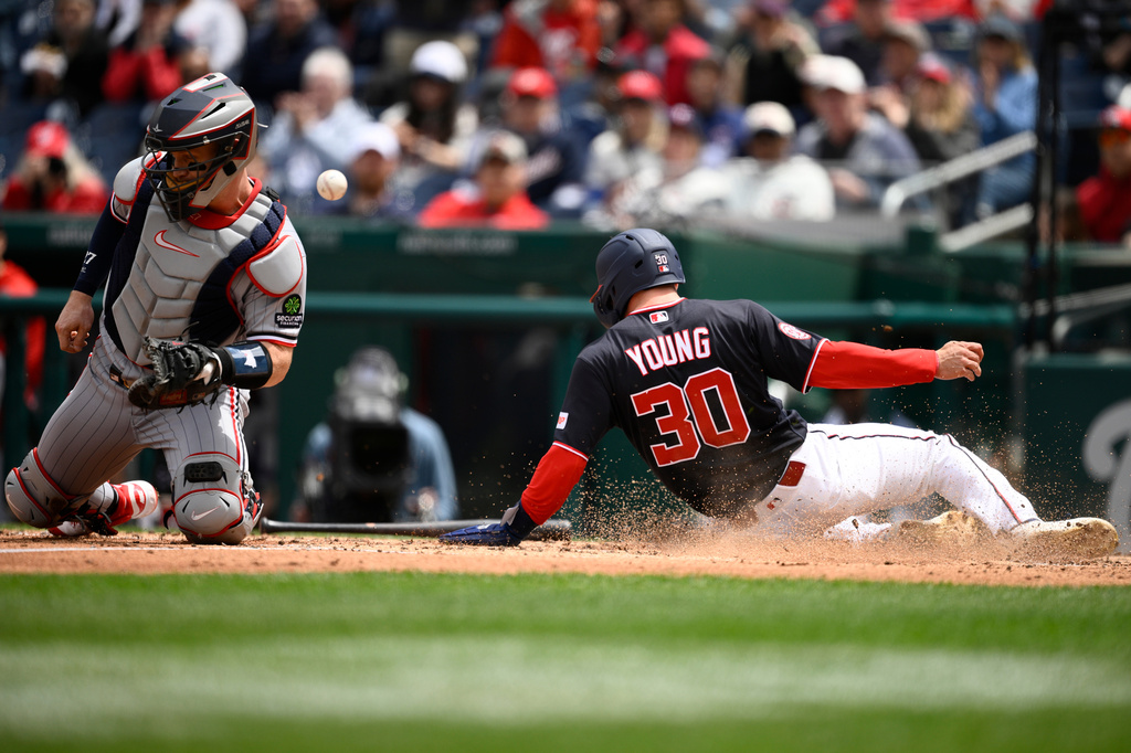 Washington Nationals' Jacob Young (30) slides home to score on a double by Keibert Ruiz as Minnesota Twins catcher Ryan Jeffers, left, tries to field the throw during the third inning of a baseball game, Thursday, May 7, 2026, in Washington. (AP Photo/Nick Wass)