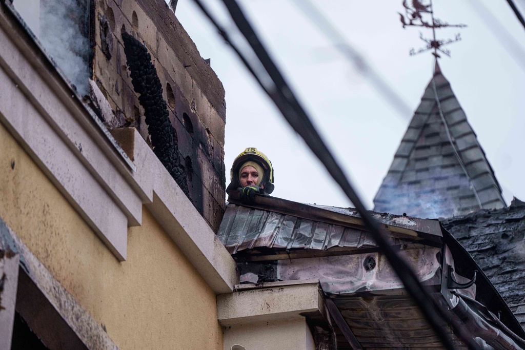 A rescue worker clears the rubble of a house destroyed after a Russian strike on Kyiv, Ukraine, on Saturday, Dec. 27, 2025. (AP Photo/Evgeniy Maloletka)