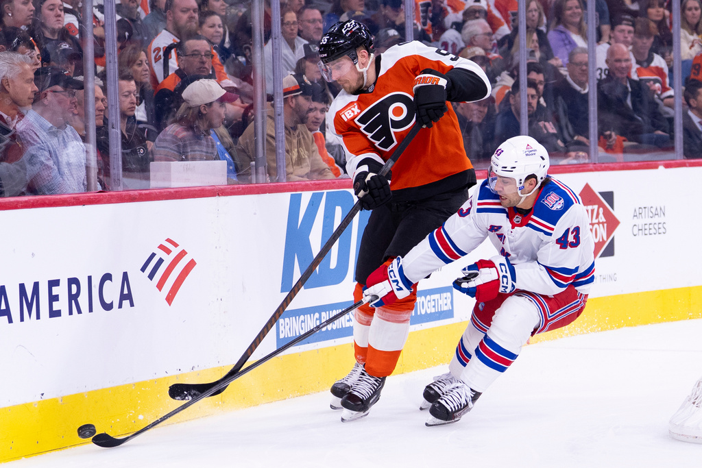 Philadelphia Flyers defenseman Rasmus Ristolainen, left, battles with New York Rangers left winger Conor Sheary for the puck along the boards during the first period of an NHL hockey game, Monday, March 9, 2026, in Philadelphia. (AP Photo/Chris Szagola)