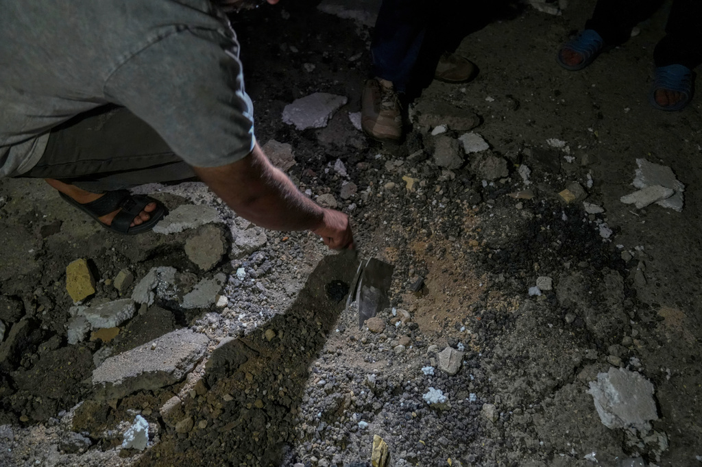 A man examines the impact site of a projectile following a strike in Lamerd, southern Iran, Saturday, Feb. 28, 2026. (Alireza Ameri/Tasnim News Agency via AP)