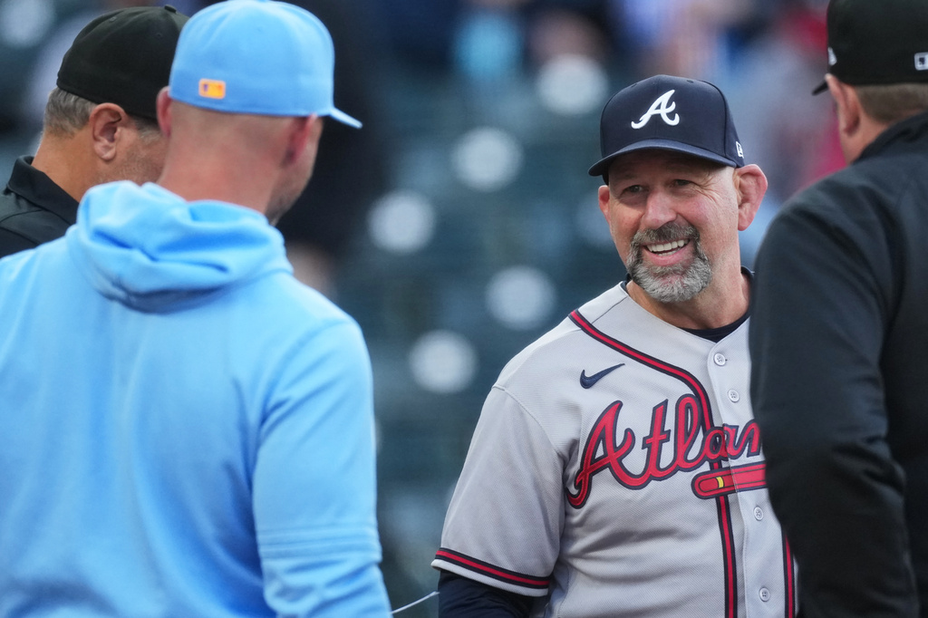 Colorado Rockies manager Warren Schaeffer, front left, greets Atlanta Braves manager Walt Weiss, back right, as they exchange lineup cards at home plate before a baseball game Friday, May 1, 2026, in Denver. (AP Photo/David Zalubowski)