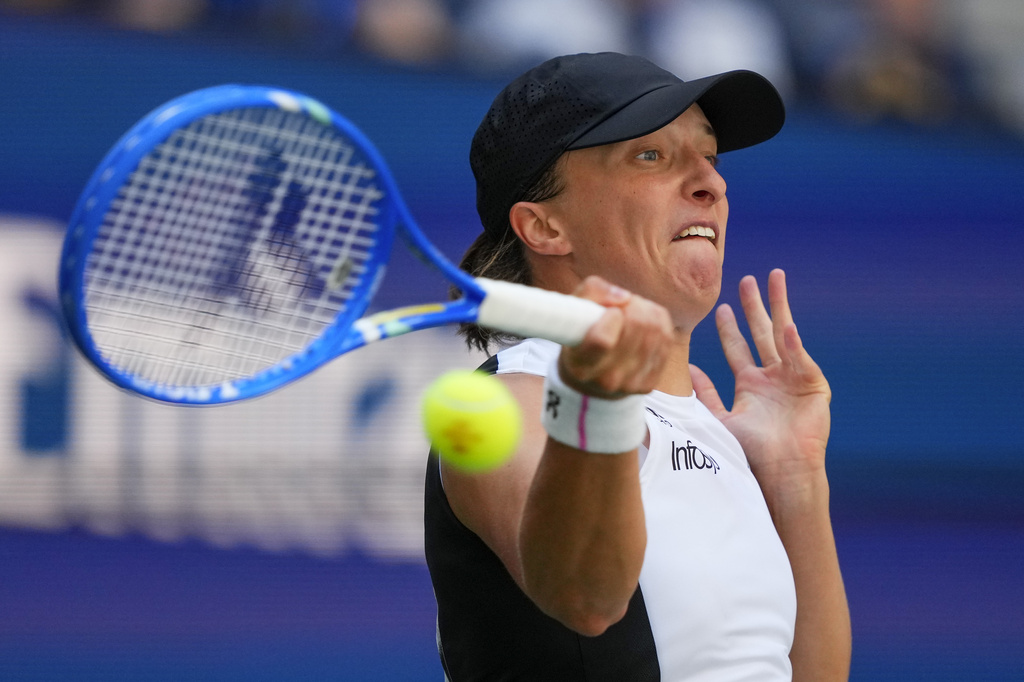 Iga Swiatek, of Poland, returns a shot to Emiliana Arango, of Colombia, during the first round of the US Open tennis championships, Tuesday, Aug. 26, 2025, in New York. (AP Photo/Yuki Iwamura)
