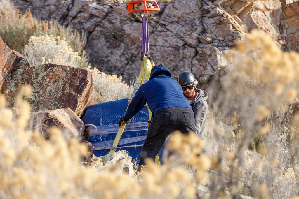 This photo provided by The Church of Jesus Christ of Latter-day Saints shows a rock bearing petroglyphs created by the ancestors of the Northwestern Band of the Shoshone Nation being returned to a location near the Utah-Idaho border, on Thursday, Dec. 11, 2025. (The Church of Jesus Christ of Latter-day Saints via AP)
