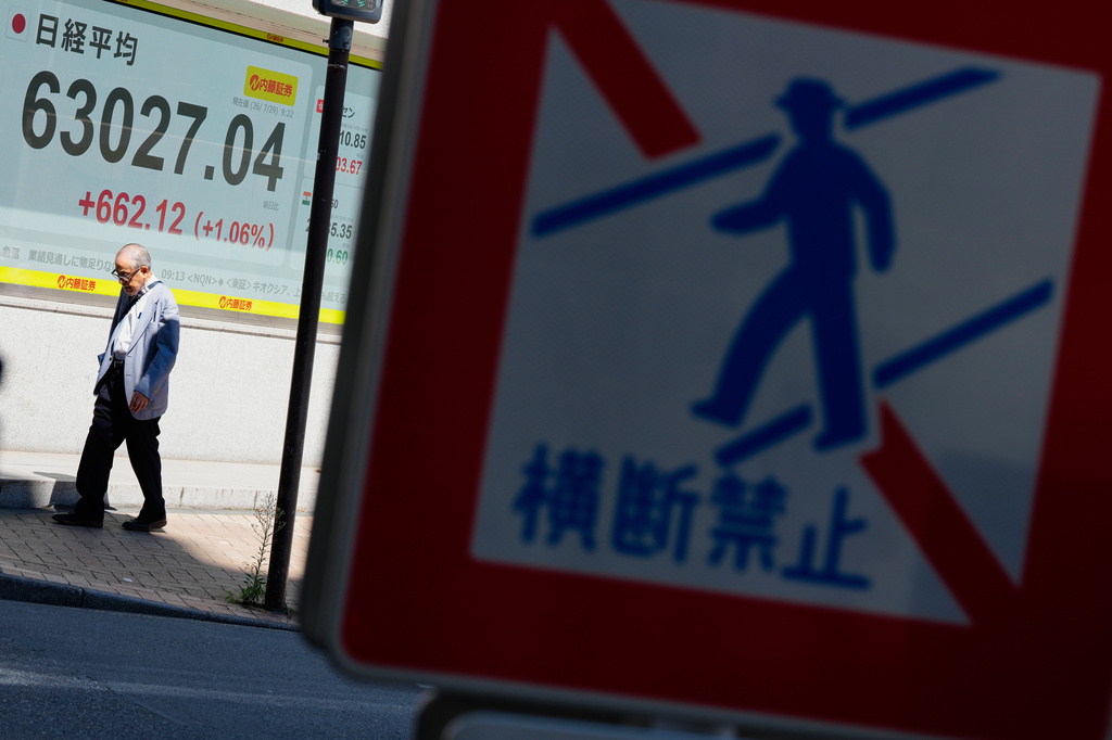 A person walks past an electronic board showing Japan's Nikkei index at a securities firm Wednesday, July 29, 2026, in Tokyo. (AP Photo/Eugene Hoshiko)