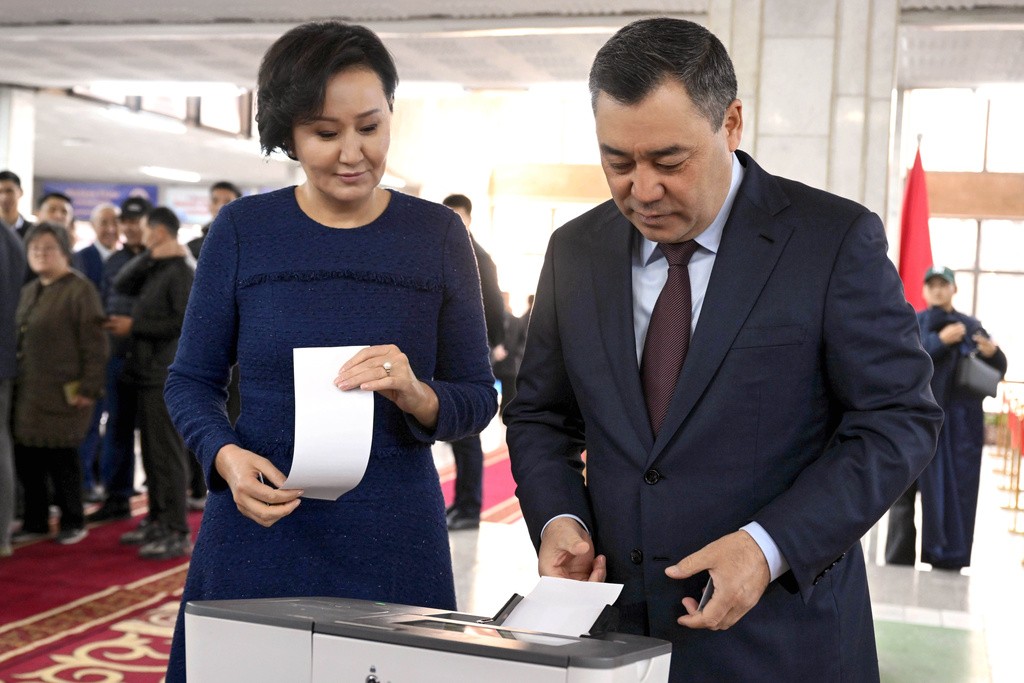In this photo provided by Kyrgyzstan's Presidential Press Office, Kyrgyz President Sadyr Japarov and his wife Aigul Japarova vote during the parliamentary elections at a polling station, in Bishkek, Kyrgyzstan, Sunday, Nov. 30, 2025. (Sultan Dosaliev,Kyrgyzstan's Presidential Press Office via AP)