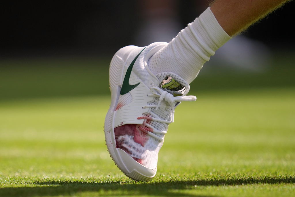 Italy's Jannik Sinner's right shoe shows a red stain during the men's singles match against Miomir Kecmanovic of Serbia at the Wimbledon Tennis Championships in London, Monday, June 29, 2026.(AP Photo/Kin Cheung)
