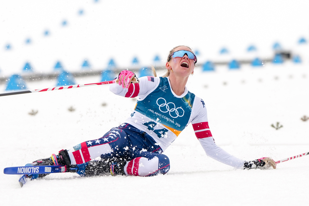 Jessie Diggins, of the United States, falls to the ground after crossing the finish line in the cross country skiing women's 10km interval start free at the 2026 Winter Olympics, in Tesero, Italy, Thursday, Feb. 12, 2026. (AP Photo/Kirsty Wigglesworth)