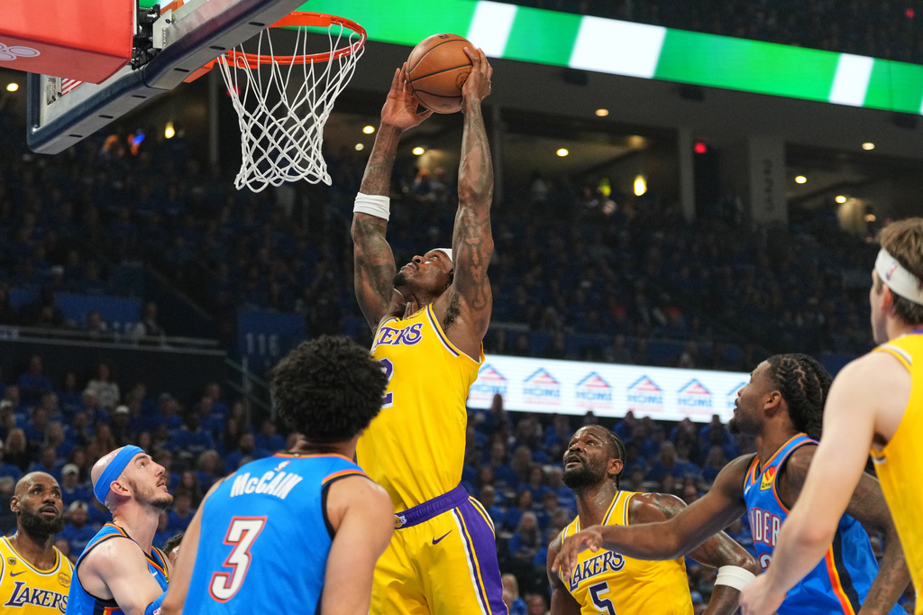 Los Angeles Lakers forward Jarred Vanderbilt, center, goes up for a shot as Oklahoma City Thunder's Jared McCain (3) and Alex Caruso, second from left, defend in the first half of Game 1 in a second-round NBA basketball playoffs series Tuesday, May 5, 2026 in Oklahoma City. (AP Photo/Kyle Phillips)