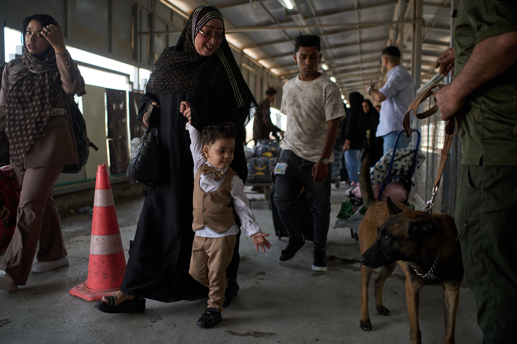 People who arrived from Iran cross the Shalamcheh border crossing between Iran and Iraq, near Basra, Iraq, Sunday, March 29, 2026. (AP Photo/Leo Correa)