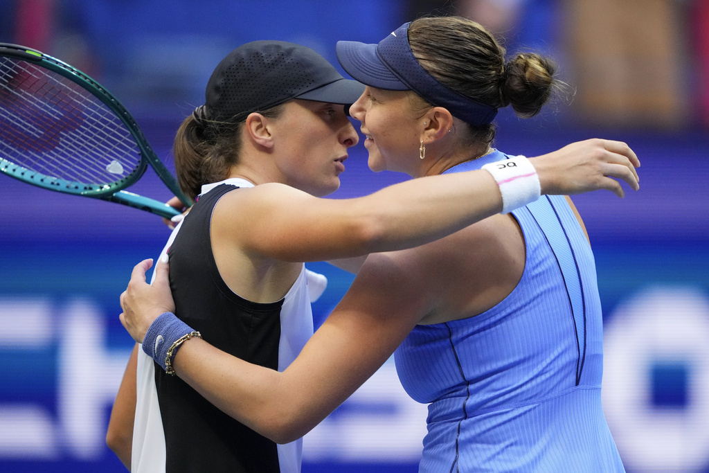 Iga Swiatek, of Poland, hugs Amanda Anisimova, of the United States, after Anisimova defeated Swiatek during the quarterfinal round of the U.S. Open tennis championships, Wednesday, Sept. 3, 2025, in New York. (AP Photo/Yuki Iwamura)