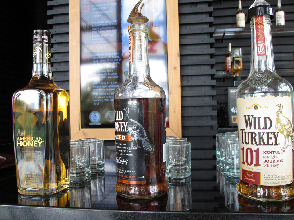 FILE- In this Aug. 22, 2014, file photo, Wild Turkey sampling bottles sit on the bar at the distillery's visitors' center near Lawrenceburg, Ky. (AP Photo/Bruce Schreiner, File)