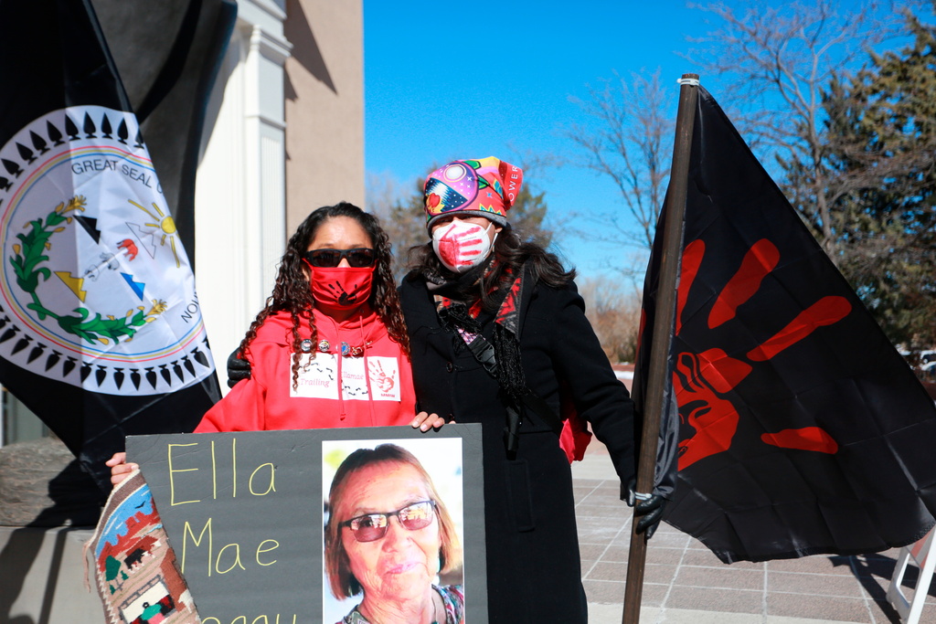 Seraphine Warren, left, poses for a photo with New Mexico state Sen. Shannon Pinto outside the state capitol building Feb. 4, 2022, while holding a poster with Warren's aunt Ella Mae Begay's photo on it in Santa Fe, N.M. (AP Photo/Cedar Attanasio, File)
